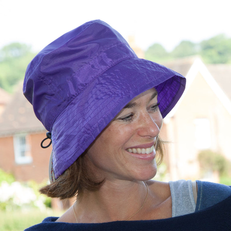 Purple packable summer rain hat on woman